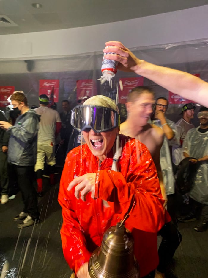 Sheree McMullen holds the Phillies’ liberty bell as she gets drenched with beer during the team’s celebration after clinching a trip to the World Series.